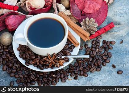 Cup of coffee on Christmas background with cinnamon, star anise and coffee beans
