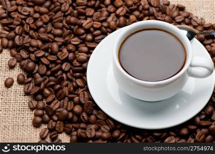 Cup of coffee on coffee grains. A hot drink