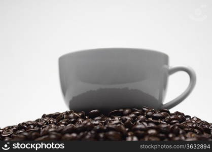 Cup of coffee on heap of coffee beans