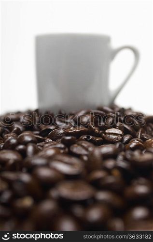 Cup of coffee on heap of coffee beans