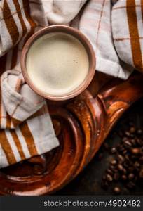 cup of coffee on rustic wooden background with towel, top view