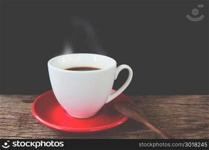 Cup of coffee on rustic wooden table on black background, Vintage and retro filter effect