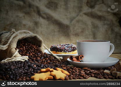 Cup of coffee on saucer and coffee beans