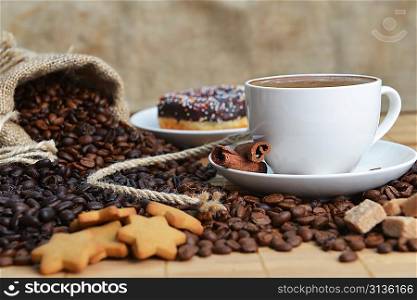 Cup of coffee on saucer and coffee beans