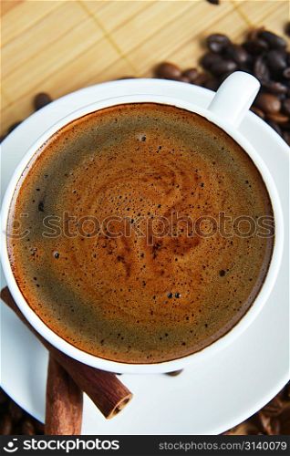 Cup of coffee on saucer and coffee beans