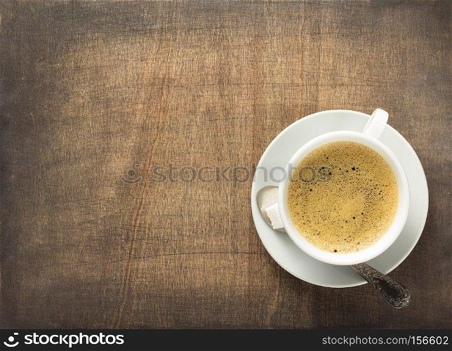 cup of coffee on wooden background, top view