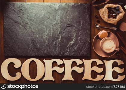 cup of coffee on wooden table background, top view