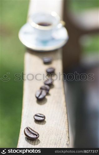 Cup of coffee on wooden table. Small miniature cup