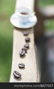 Cup of coffee on wooden table. Small miniature cup