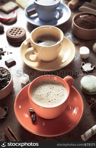 cup of coffee, tea and cacao at abstract background texture, top view