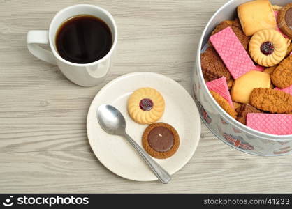 Cup of coffee with a tin filled with biscuits