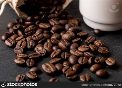 Cup of coffee with beans as background. A cup of coffee with coffe beans as background