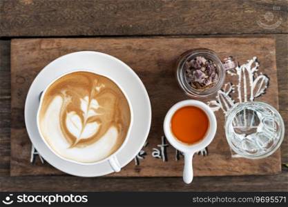 Cup of coffee with beautiful Latte art on wooden table background