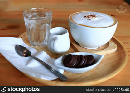 Cup of coffee with biscuits on table