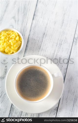 Cup of coffee with bowl of ghee