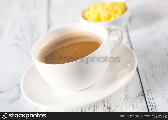 Cup of coffee with bowl of ghee