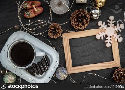 Cup of coffee with chocolate chip cookies and Christmas decoration with Empty wooden frame for work about design element. Selective focus, Top view, copy space