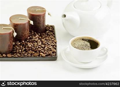 Cup of coffee with coffee beans and candles
