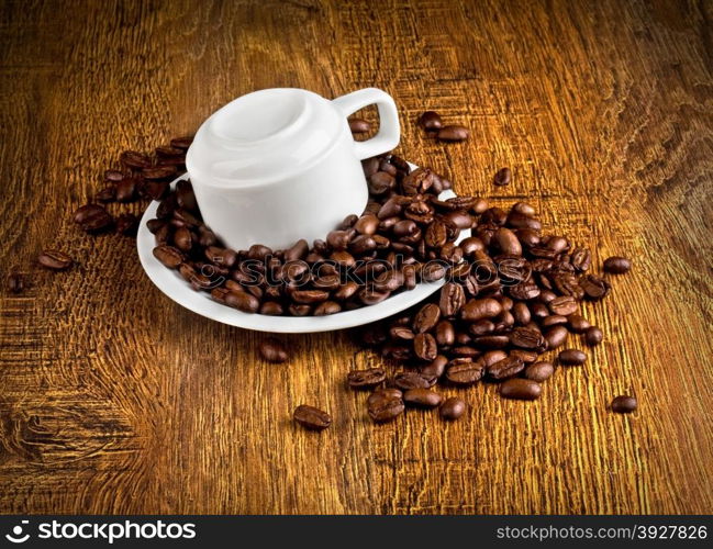 Cup of coffee with coffee beans on a wooden background.