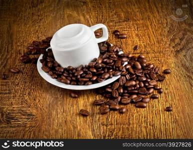 Cup of coffee with coffee beans on a wooden background.