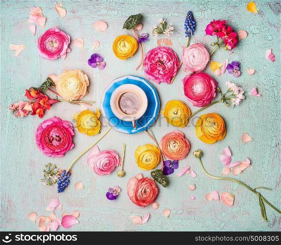 Cup of coffee with colorful flowers on turquoise blue shabby chic background, top view, flat lay