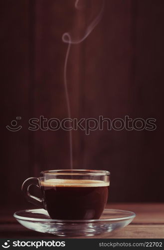 Cup of coffee with fume on the wooden background. Cup of coffee with fume