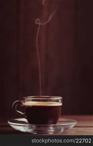 Cup of coffee with fume on the wooden background. Cup of coffee with fume