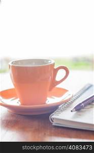 Cup of coffee with pen and notebook, stock photo