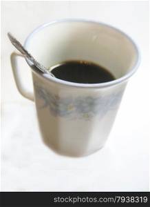Cup of coffee with teaspoon on the white background