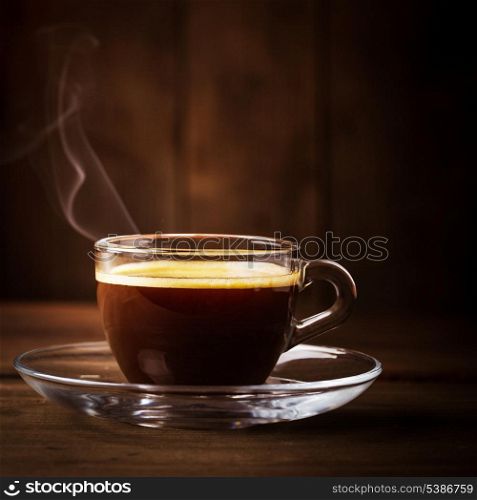 Cup of coffee with &#xA;fume on the wooden background
