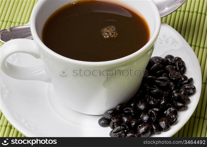 Cup of expresso coffee on a green tablecloth