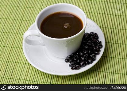 Cup of expresso coffee on a green tablecloth