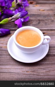 cup of fragrant black coffee on a gray table, close up