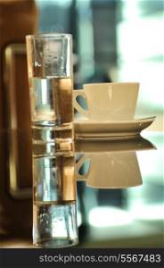 cup of fresh coffeee in restaurant with glass of water