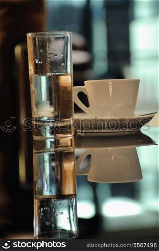 cup of fresh coffeee in restaurant with glass of water