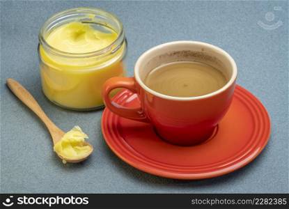 cup of fresh fatty coffee with ghee (clarified butter) and MCT oil - ketogenic diet concept