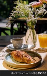Cup of fresh hot coffee, orange juice and traditional french croissant on table of parisian outdoor cafe in paris