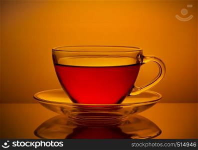 Cup of fresh tea on an orange background. Cup of fresh tea