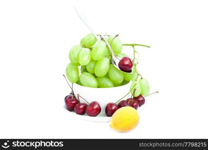cup of grapes, cherries and apricots isolated on white