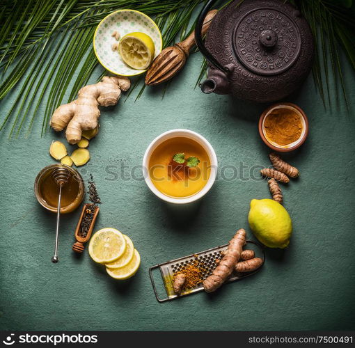 Cup of healthy herbal turmeric tea with ingredients. Top view