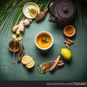 Cup of healthy herbal turmeric tea with ingredients. Top view