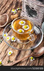 cup of herb tea with chamomile flowers. mug of herbal tea with chamomile flowers on rustic wooden table