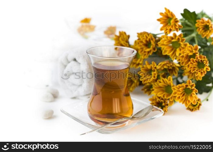 Cup of herbal tea and flowers on a white background