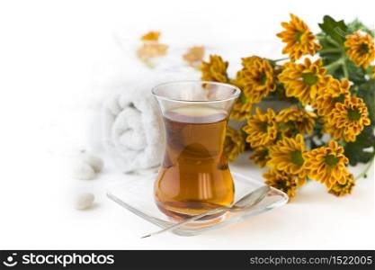 Cup of herbal tea and flowers on a white background