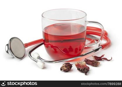 Cup of hibiscus tea and stethoscope on white background