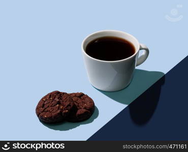 Cup of hot black coffee and fresh chocolate cookies on color block blue background