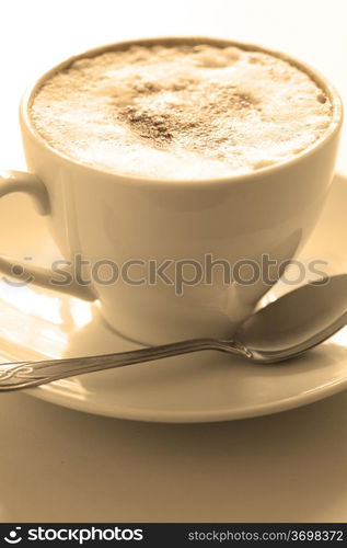 Cup of hot cappuccino, close-up. At the bottom copyspace. Image tinted