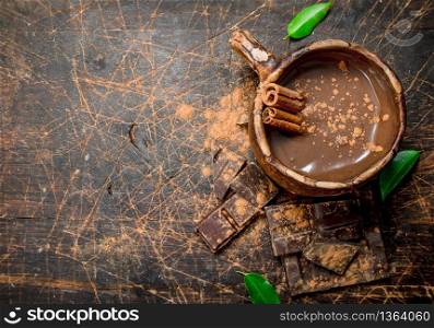 Cup of hot chocolate with cinnamon sticks. On a wooden background.. Cup of hot chocolate with cinnamon sticks.