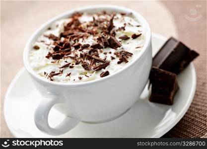 Cup of hot cocoa with shaved chocolate and whipped cream