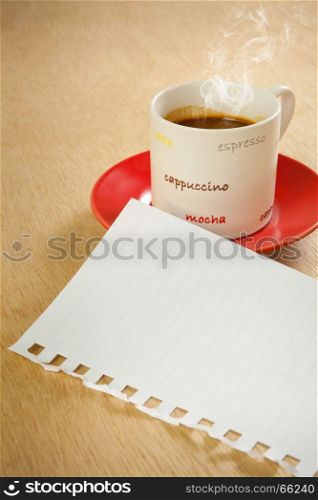 cup of hot coffee and note paper on wood background